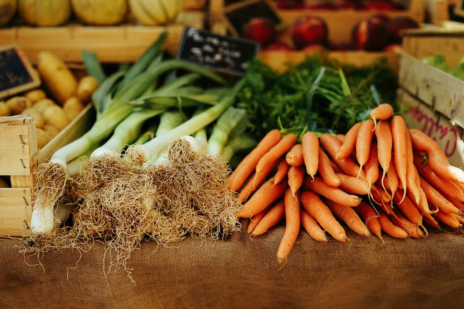 Fresh vegetables and herbs stacked at a market stall